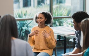 During a group therapy session for teenagers, a teenage girl discusses her emotions.